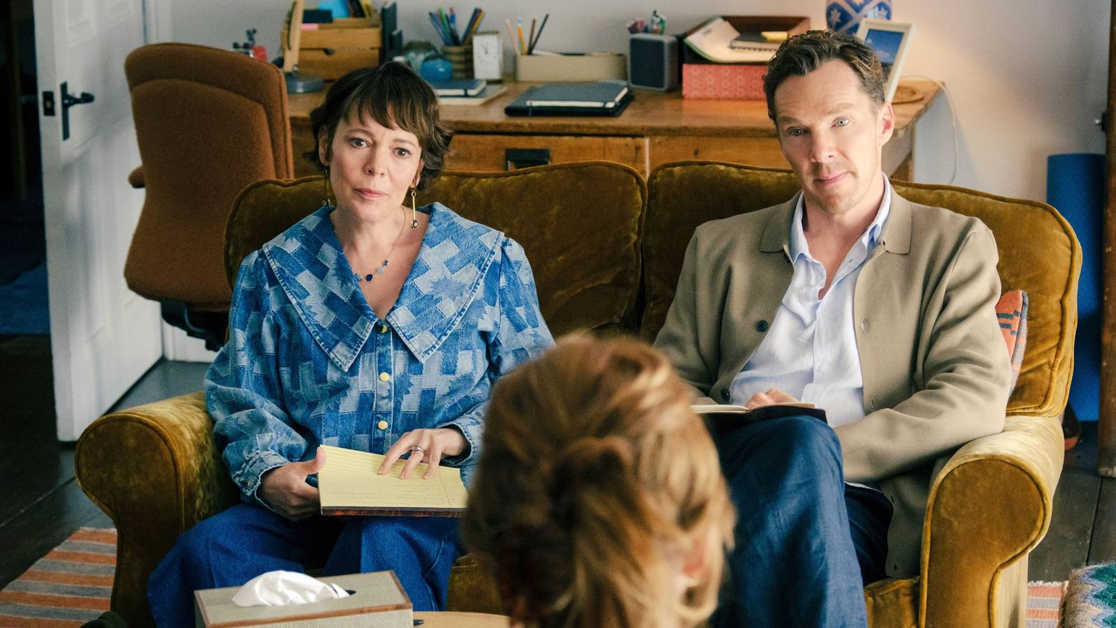 olivia-colman-and-benedict-cumberbatch-sitting-on-a-couch-staring-at-a-therapist-in-the-roses.jpg