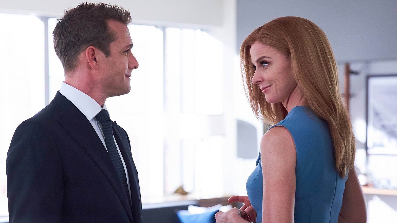 donna-and-harvey-smirking-at-one-another-in-suits.jpg