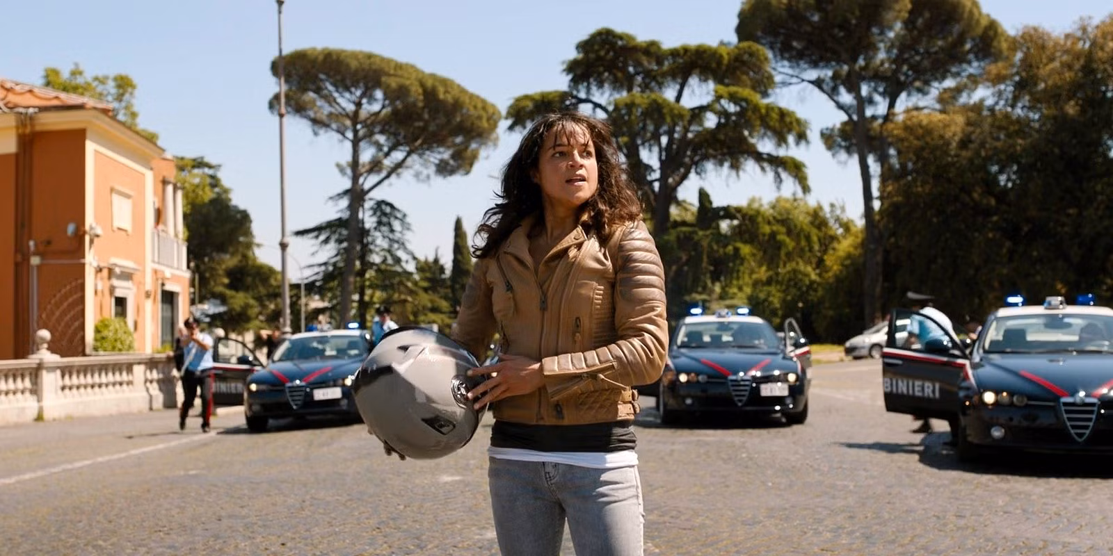 Why The Franchise Needs To Prioritize Its Conclusion letty-holding-a-motorcycle-helmet-while-surrounded-by-police-in-fast-x.jpg