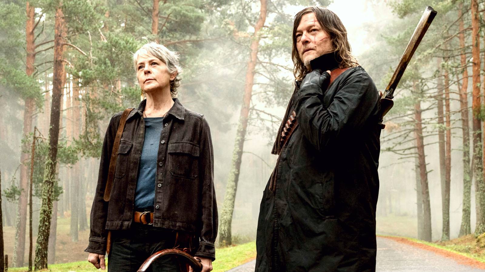 melissa-mcbride-holding-a-bow-and-norman-reedus-with-a-rifle-over-his-shoulder-standing-on-a-road-wi.jpeg