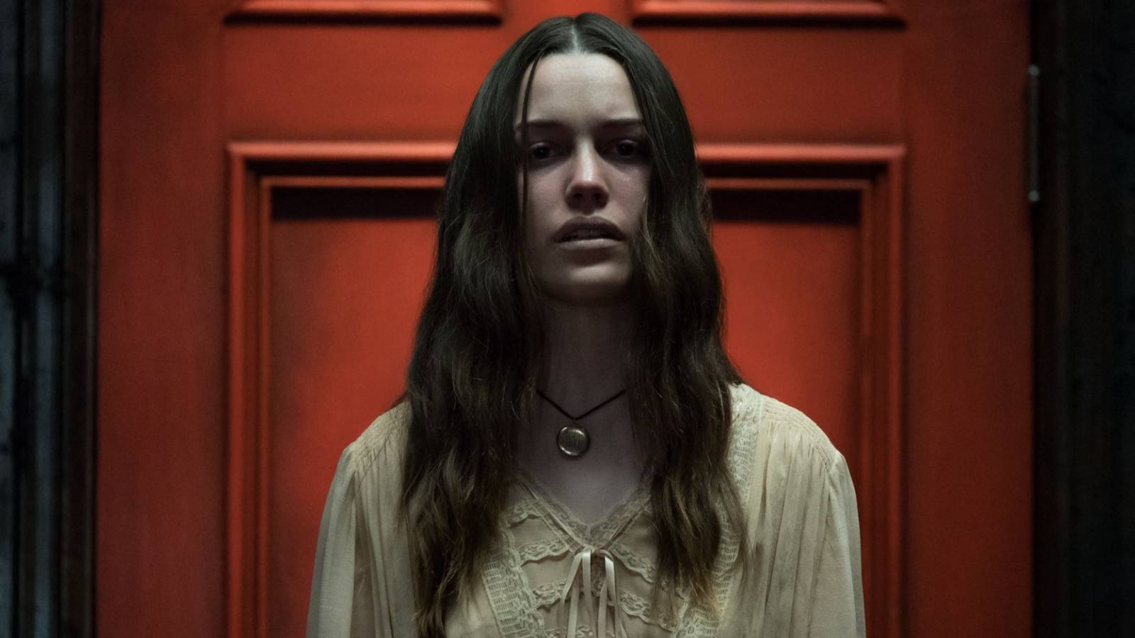 nell-victoria-pedretti-standing-in-front-of-a-red-door-in-a-trance-in-the-haunting-of-hill-house.jpg