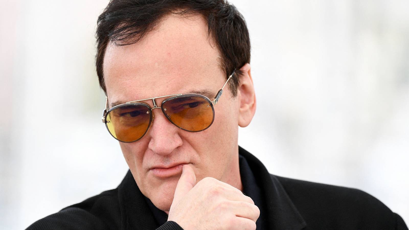 The Art of the Perfect Needle Drop: Iconic Movie Music Moments quentin-tarantino-peers-forward-intently-while-attending-an-event.jpg