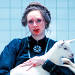 gwendoline-christie-with-blood-on-her-face-holding-a-baby-goat-as-lorne-in-severance-season-2-finale.avif
